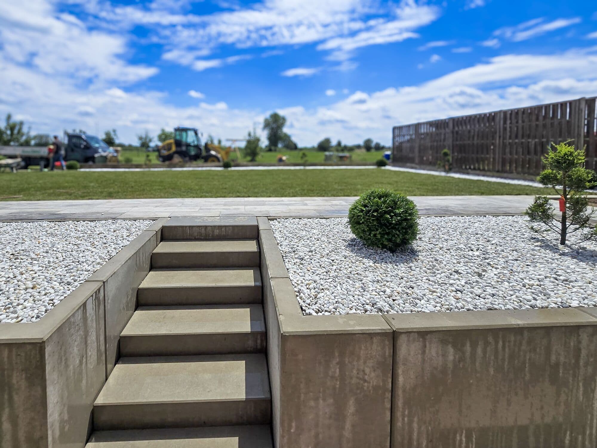Betontreppe zwischen zwei Kiesbeeten mit Einfassung aus Betonwinkeln