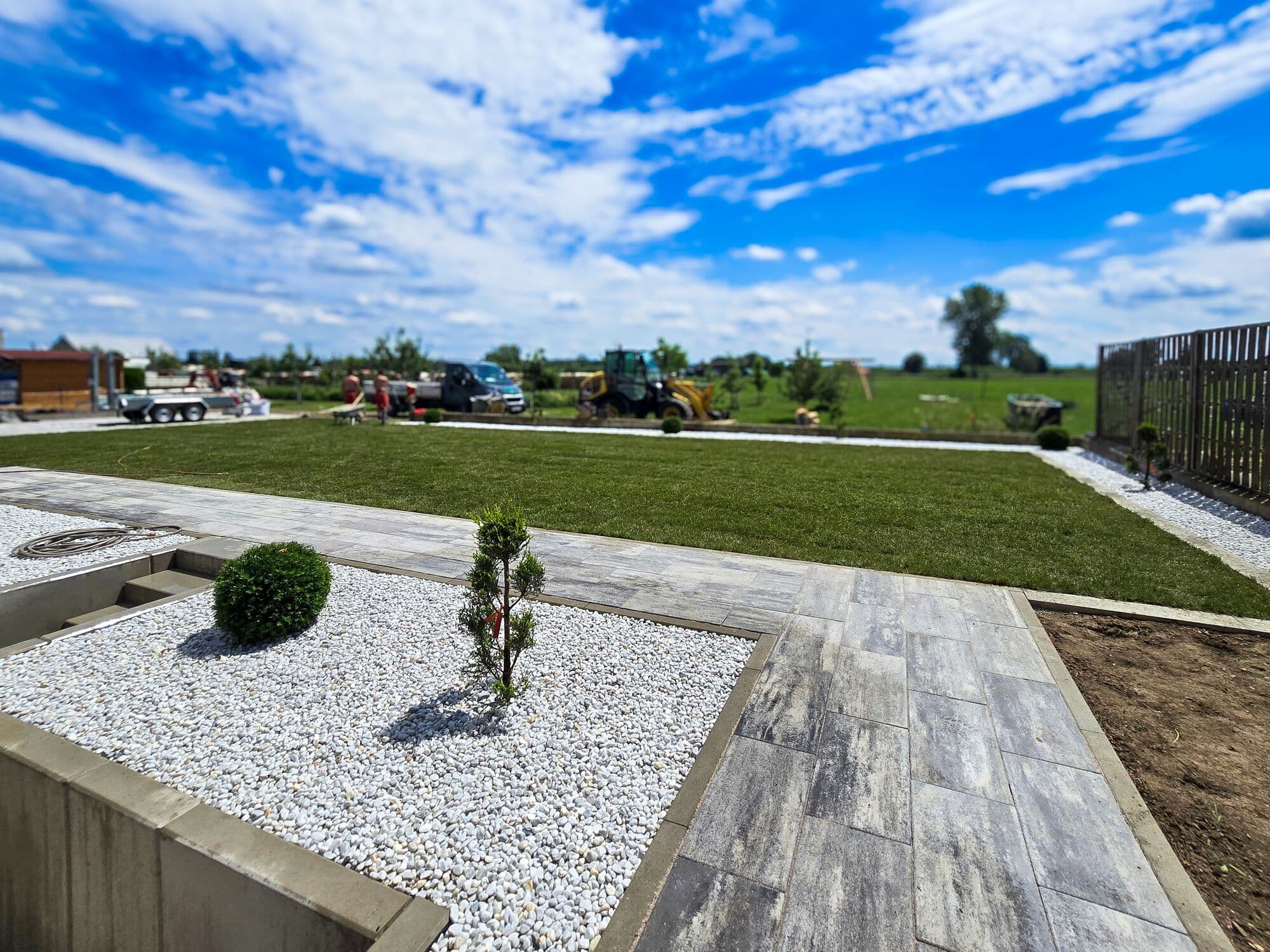 Garten mit Kiesbeet, Betoneinfassung, Plattenweg und Rasenfläche